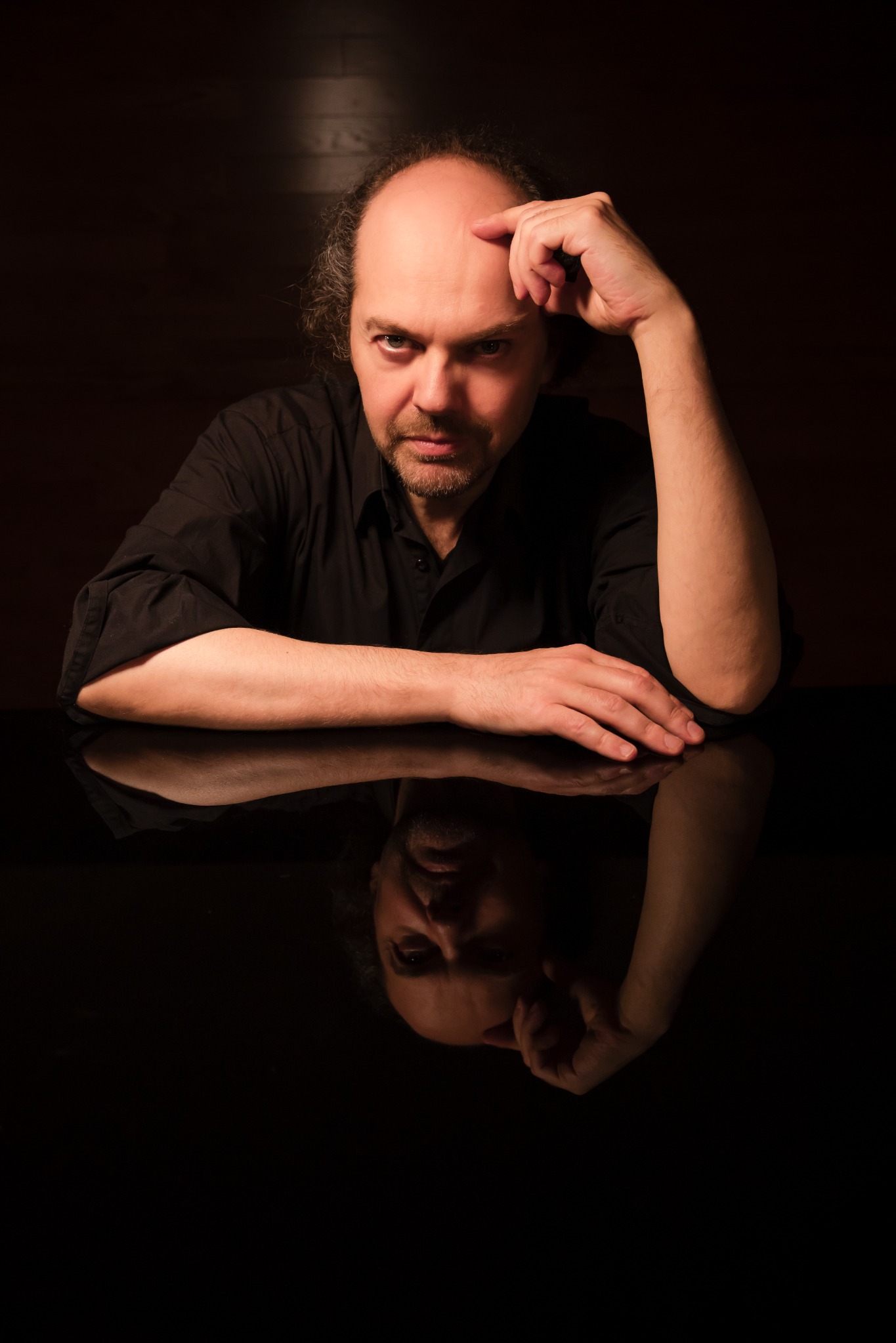 Octavio Vázquez seated at a reflective black surface